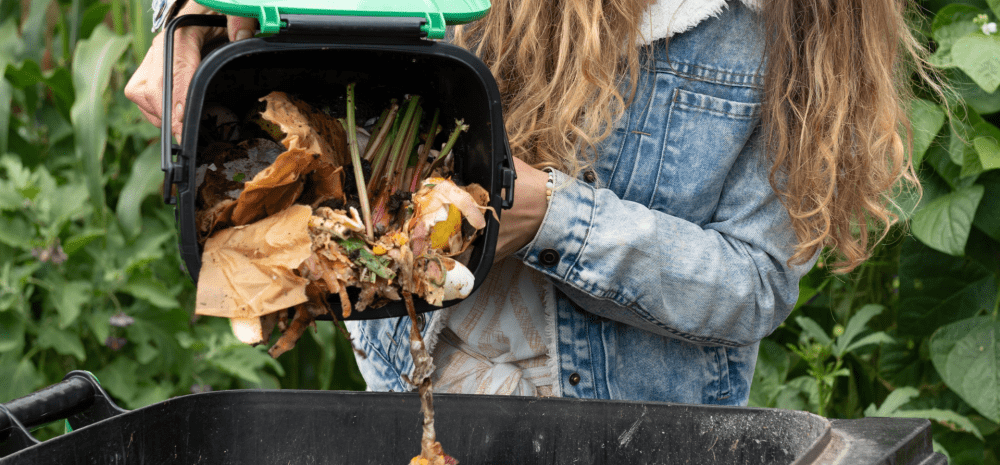 a person putting compost into their bin