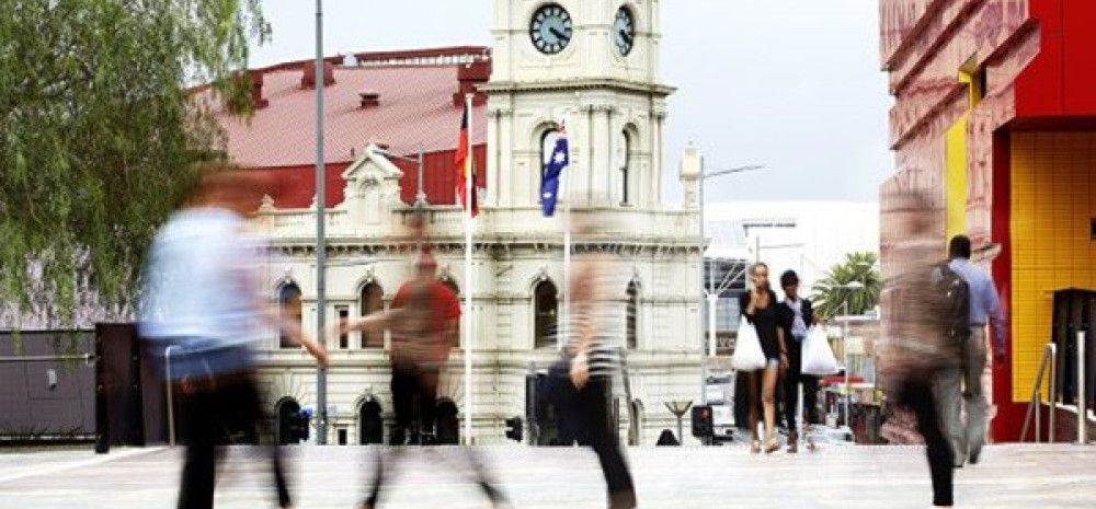 people walking in Dandenong with drum thearte in thebackground