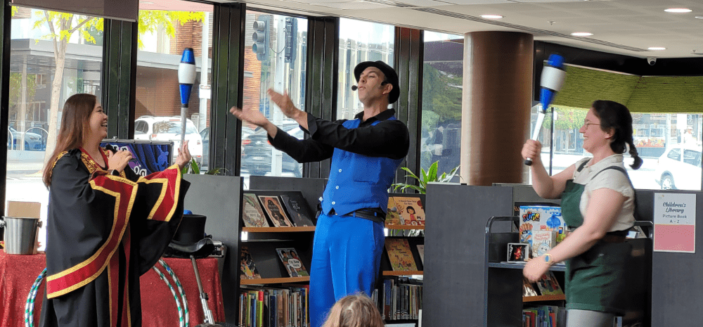 Mayor and Mr Marvel juggling in a library