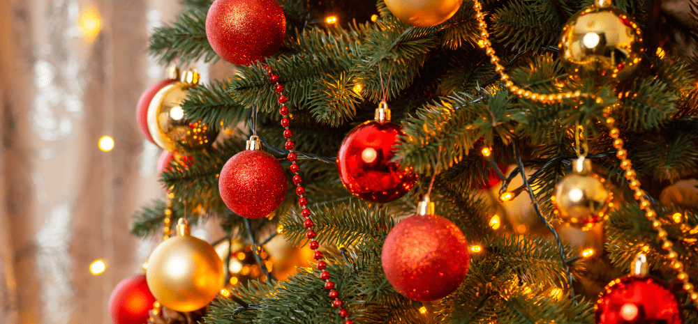 A close up of a Christmas tree with red and gold baubles.