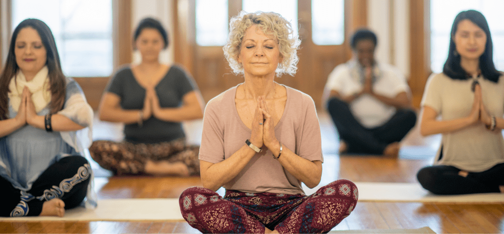 A group of women sitting on the floor doing yoga.