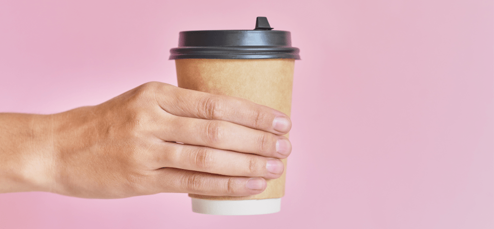 Hand holding a disposable coffee cup