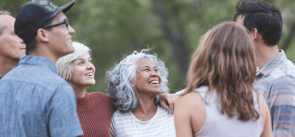 A group of people standing looking happy