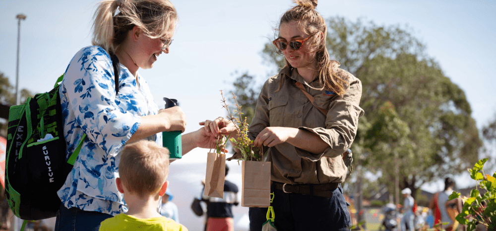 Staff memeber giving community member a plant