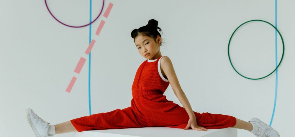 A girl doing gymnastic wearing red clothes.
