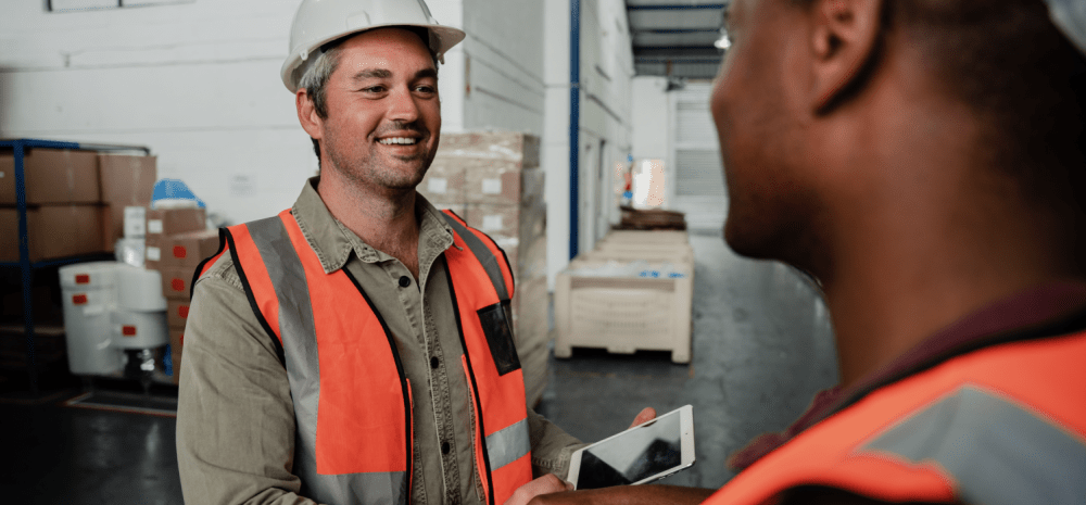 Two workers wearing safety gear at a worksite