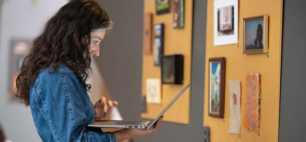 A person looking at a laptop at an exhibition