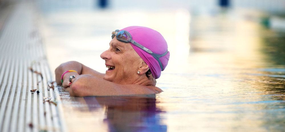 Older women leaning on edge of the pool in the water