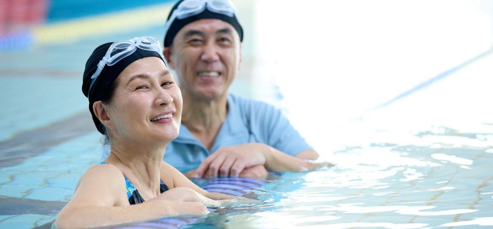 Two adults in the pool smiling