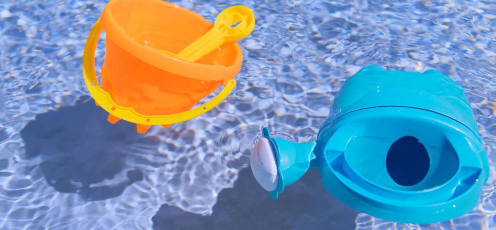 Bucket, spade and watering can floating in a pool