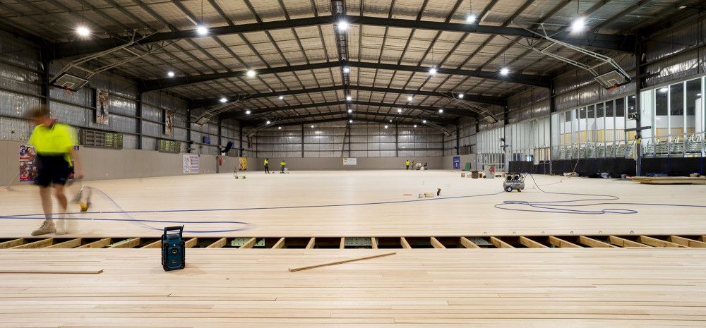 Workers complete the timber flooring at the Dandenong Stadium