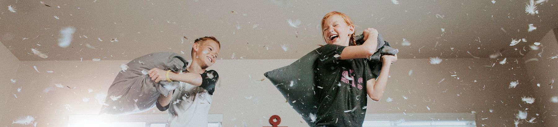 two kids having a pillow fight