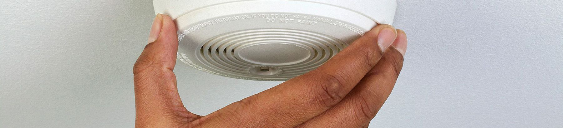 Someone fitting a smoke alarm