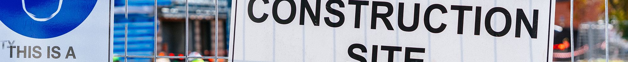 Construction site with construction signs on a fence