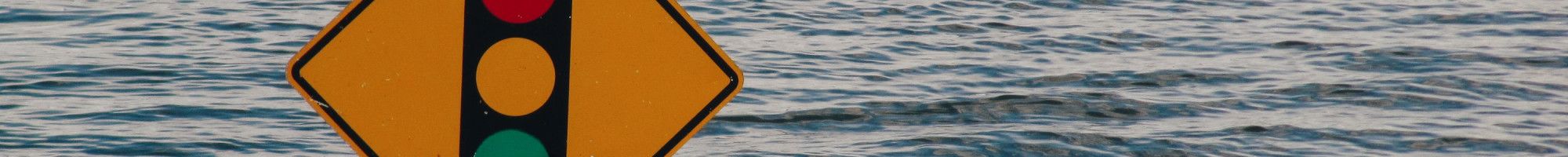 Flood water reaching traffic light sign