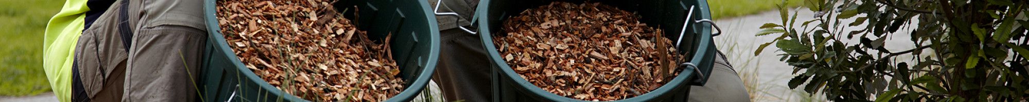 Two Parks team members adding mulch to a garden