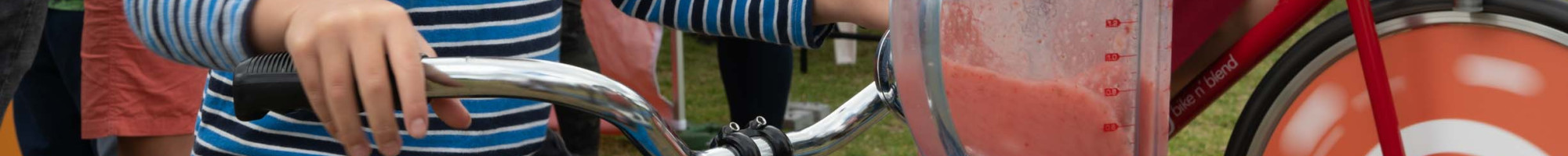 A child rides a bike to power a blender mixing a smoothie.