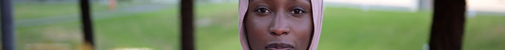 Portrait of Danya Daoud in a pink headscarf and white top.