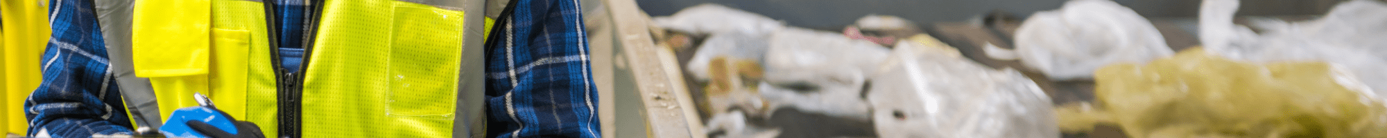 A person looking at waste in an industrial bin.