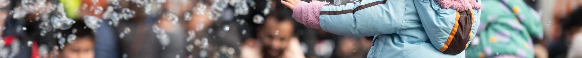 Crowd of people enjoying bubble performance 