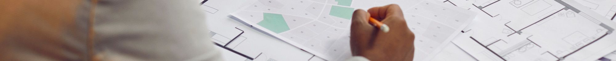 Person making changes to a plan on a table
