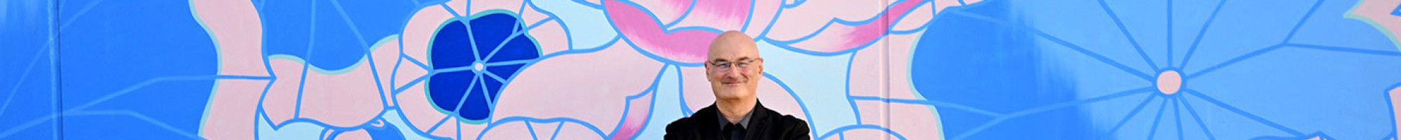 Cr Sean O'Reilly standing in front of a mural