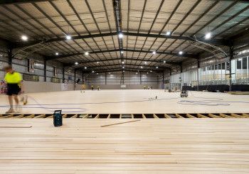 Workers complete the timber flooring at the Dandenong Stadium