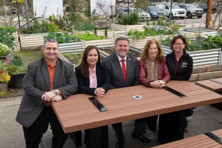 A group of people sitting at a new outdoor table at Noble Park Community Centre