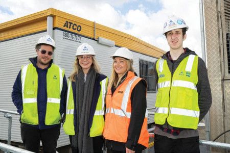 Four people smiling in visy vests