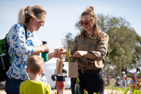 Staff memeber giving community member a plant