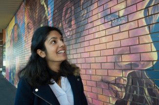 Aishwarya Pokkuluri in front of Between Two Worlds Mural