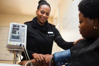 nurse taking blood pressure of patient