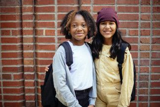 Two girls on brick wall