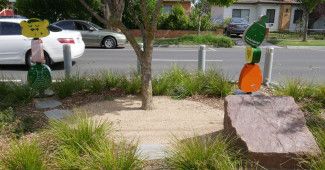 Sculptures and a garden with a plaque on a rock.