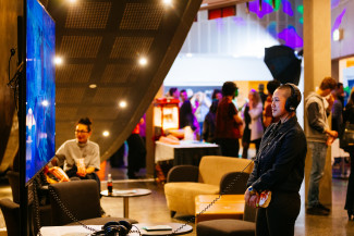 Person in a theatre foyer watching something on a screen