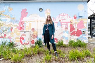 Sasha Heath standing in front of 'The Noble Community' mural