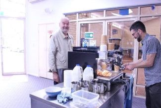 a person serving a person at a coffee machine