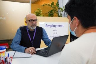 two people sitting at a desk talking