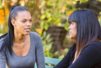 two women speaking outside