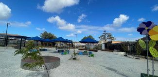 Landscaped area with tables and umbrellas.