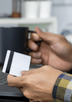 A person shopping online with a credit card and a laptop computer