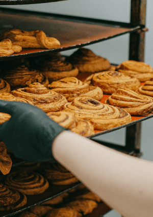 A baker loading pastries on to a rack.