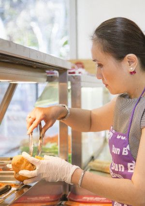 A lady preparing the Bánh Mì
